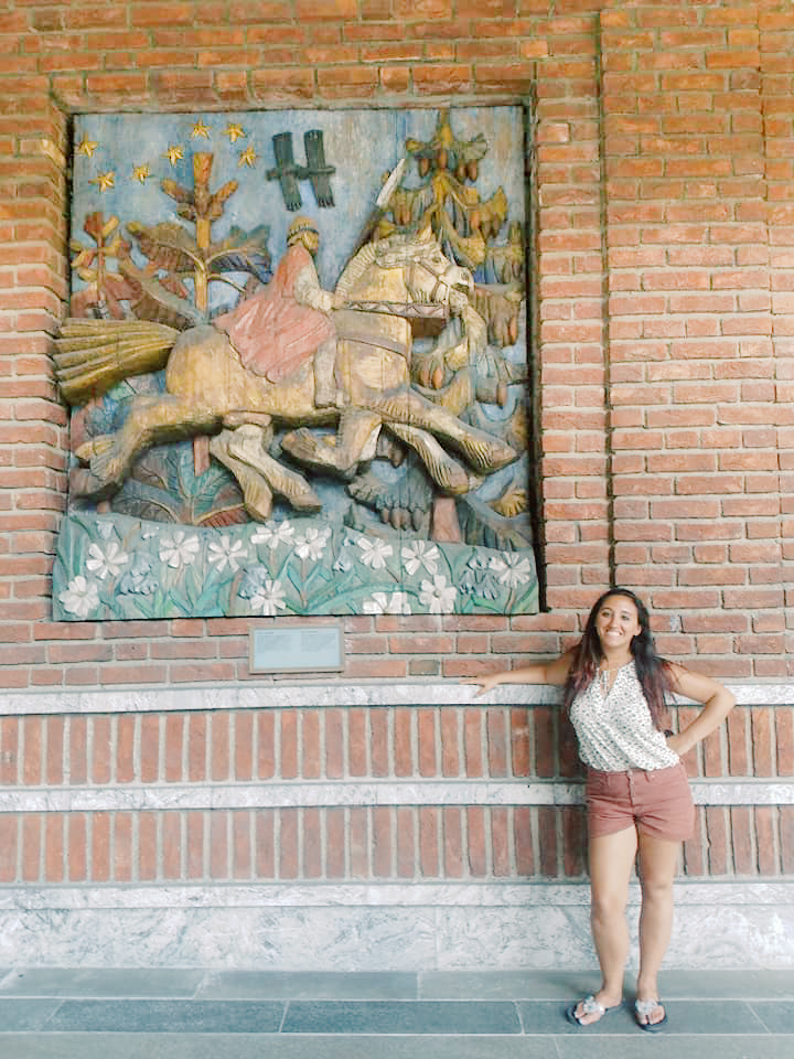 A woman poses beside a mural outside of Oslo's city hall