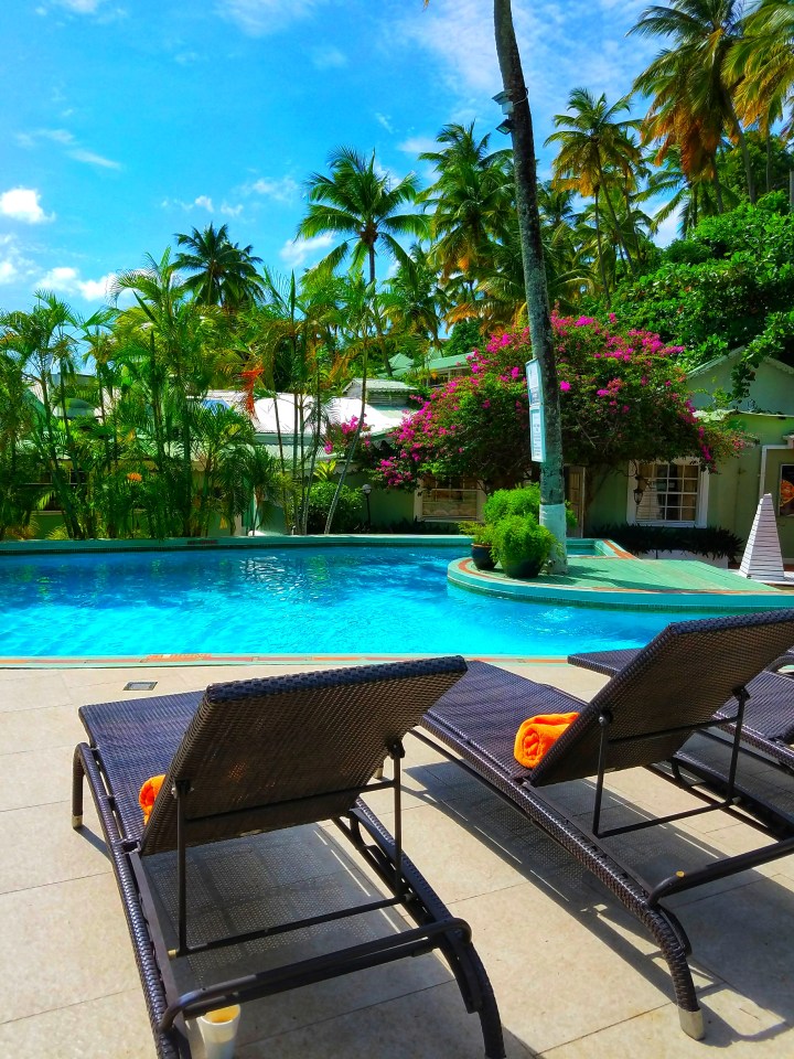 Lounge chairs sit around a beautiful but small infinity pool. It is the perfect place to lounge on a trip to St Lucia with a friend