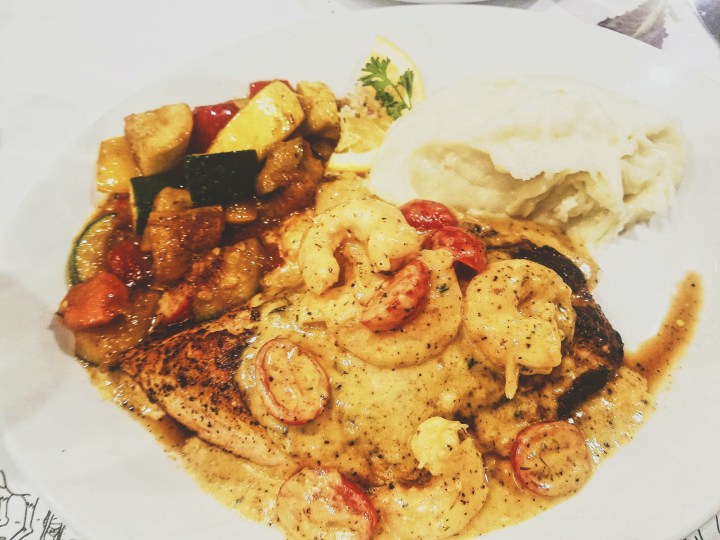 Veal and shrimp covered in brie and cream with a side of vegetables and a side of mashed potatoes served at K-Paul's Louisiana Kitchen.