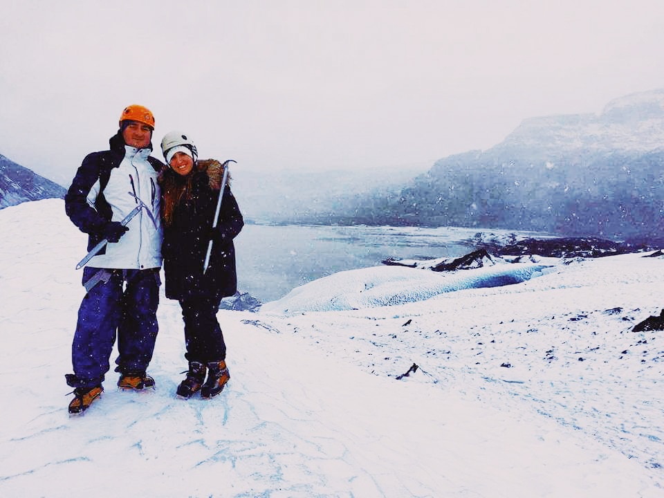 A couple poses for a picture as they climb Solheimajokull in Iceland