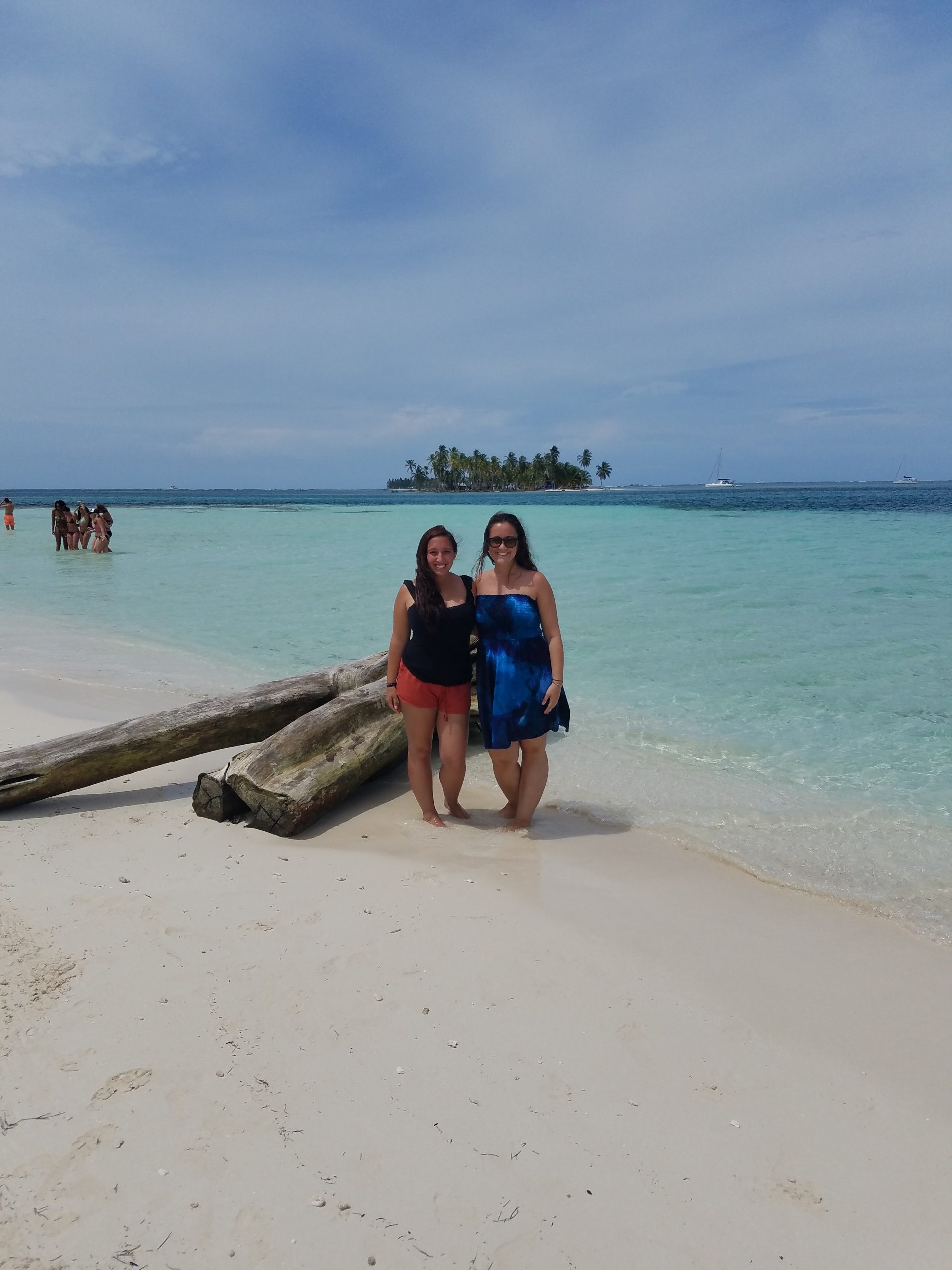 Two women pose for a photo on the beach